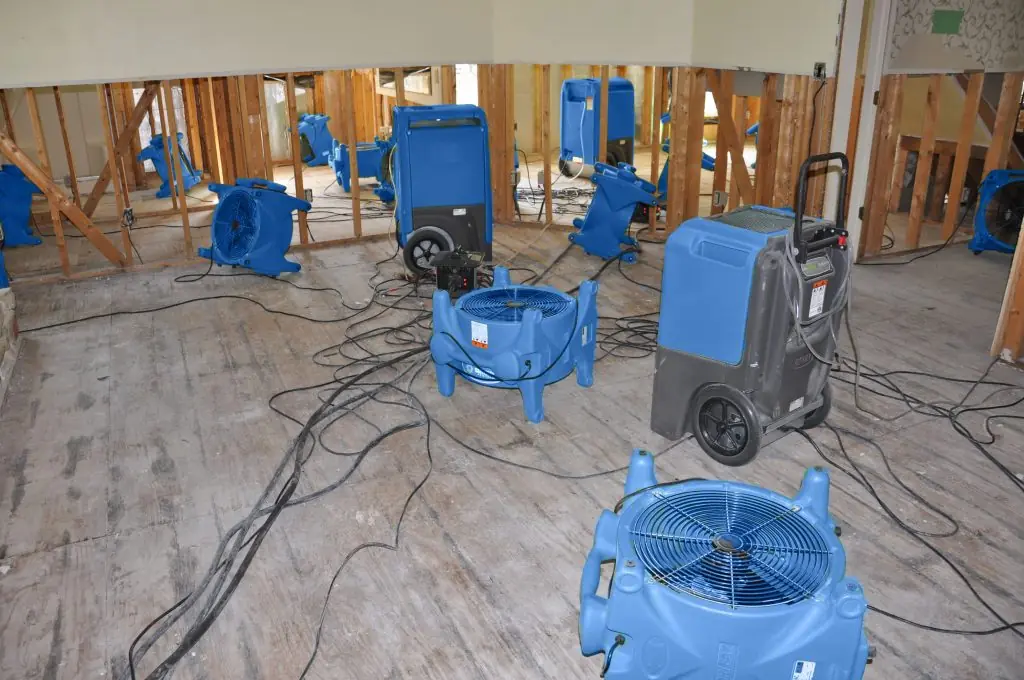 Air movers drying a gutted Boston room after major water damage